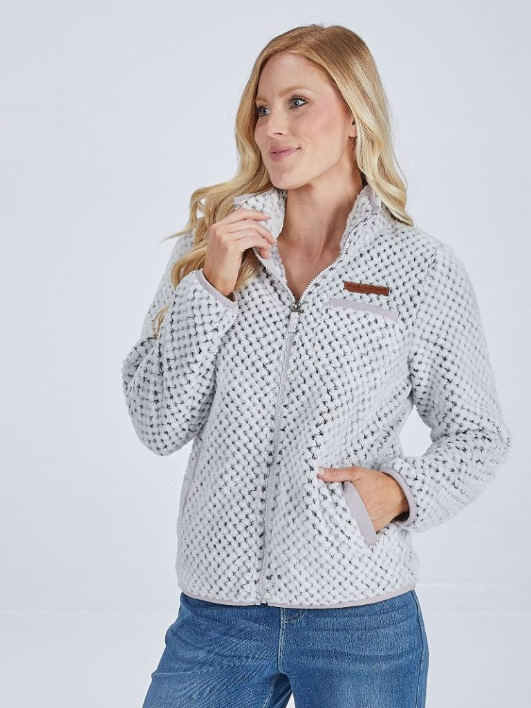 Woman wearing a patterned shirt with a plain background