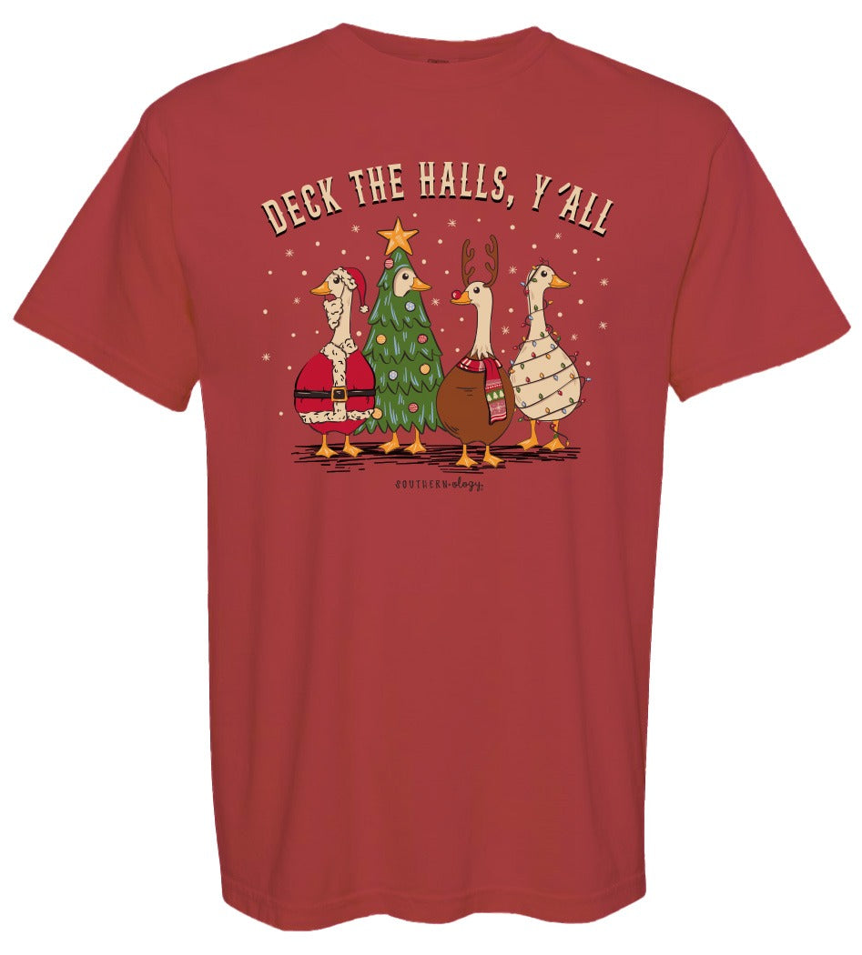 A red short-sleeve t-shirt with a Christmas-themed graphic on the front. The graphic features four cartoon geese dressed in holiday attire, with one wearing a Santa hat, one in a green Christmas tree costume, one as a reindeer, and one in a patterned sweater.